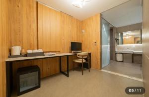 a room with a desk with a television and a bathroom at Motel Cookie in Seoul