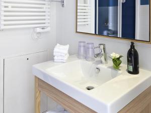 a bathroom with a white sink with a bottle of wine at Aparthotel Adagio Paris Vincennes in Vincennes