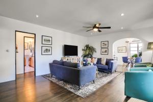 een woonkamer met twee blauwe banken en een plafondventilator bij West Beach Villa 3 & 4 in Santa Barbara