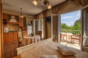 a bedroom with a kitchen and a balcony with a table at Helena in Mlini