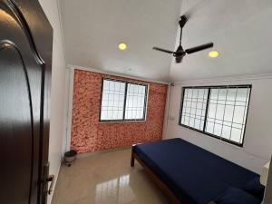 a bedroom with a blue bed and two windows at dream house fort kochi 2 in Cochin