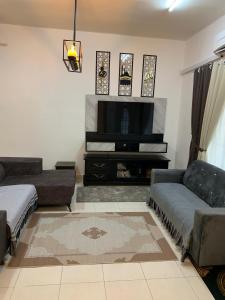 a living room with a couch and a flat screen tv at F'Seven Homestay in Bedung