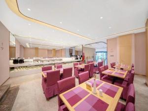 a restaurant with purple chairs and tables and a buffet at Lavande Hotel Changchun Gaoxin Jilin University in Changchun