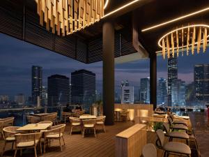 a restaurant with tables and chairs and a city skyline at All Seasons Jakarta Thamrin in Jakarta