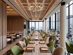 a dining room with long tables and green chairs at All Seasons Jakarta Thamrin in Jakarta