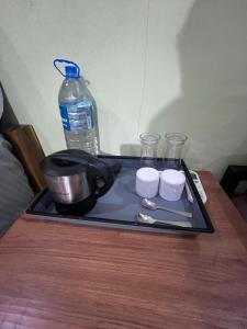 een dienblad met een pot en bekers op een tafel met een waterfles bij The Brine Breeze Gokarna in Gokarn