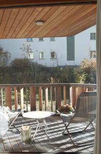 a patio with a table and a chair on a deck at Motta Rotonda in Maloja