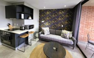 eine Küche und ein Wohnzimmer mit einer Couch und einem Tisch in der Unterkunft 2SIX2, FLORIDA ROAD in Durban
