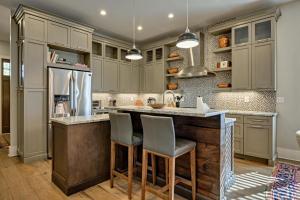 a kitchen with gray cabinets and a large island with bar stools at Dancing Bear Walk to Town in Highlands