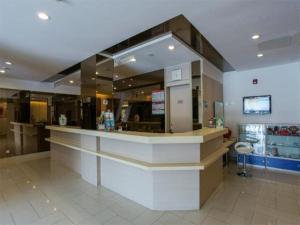 a restaurant with a counter in the middle of a room at Jingjiang Inn Wuxi Liyuan Development Zone in Wuxi