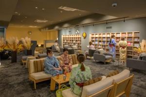 um grupo de pessoas sentadas em uma biblioteca em Tendo Hotel em Tendo