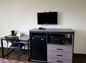 a desk with a microwave and a desk with a tv at Americas Best Value Inn Alexandria in Alexandria