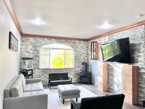 a living room with a tv and a brick wall at Family Zermatt 2BR Villa Near Park City & Deer Valley Ski Resorts - 3739 in Mound City