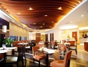 a dining room with tables and chairs in a restaurant at Ramada by Wyndham Wujiaochang Shanghai in Shanghai