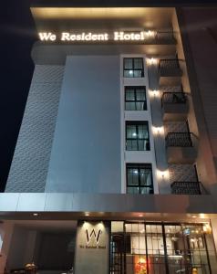 a building with a sign that reads we resident hotel at We Resident Hotel in Hat Yai