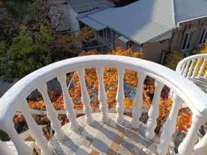 a white wooden stair railing in front of a house at Why Me Eco-friendly Hostel in Tbilisi City