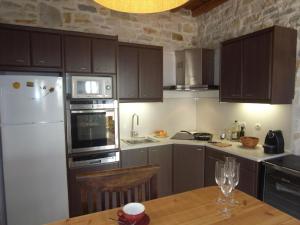 a kitchen with a white refrigerator and a wooden table at Naousa in Naousa