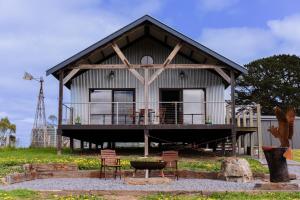 a house with a porch and chairs in front of it at The Barn at Piney Ridge Farm - Bed & Breakfast in Nairne