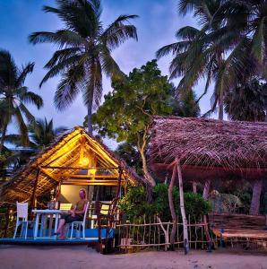 a person sitting on a porch of a house at Wellé Wadiya Beach Villa in Kalpitiya