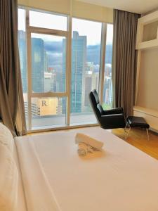 a hotel room with a bed and a chair and a window at PLATINUM Suites KLCC By AR Hospitality in Kuala Lumpur +59 photos