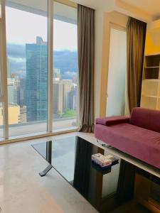 a living room with a purple couch and a large window at PLATINUM Suites KLCC By AR Hospitality in Kuala Lumpur