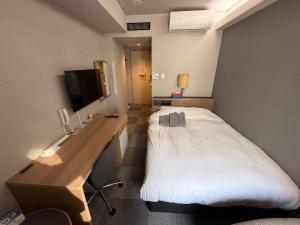 a hotel room with a bed and a desk at Hotel Tetora Spirit Sapporo in Sapporo
