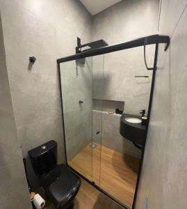 a bathroom with a sink and a glass shower at 4Kitnet nova no centro in Lavras