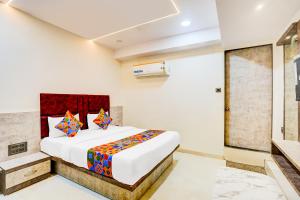 un dormitorio con una cama grande en una habitación en FabHotel Malva, en Ahmedabad