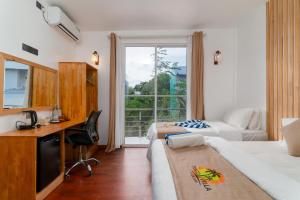 a hotel room with a desk and a bed and a window at Coco Ukulhas Villa in Ukulhas