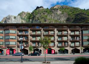 un gran edificio con una montaña en el fondo en Andorra4days Canillo, en Canillo