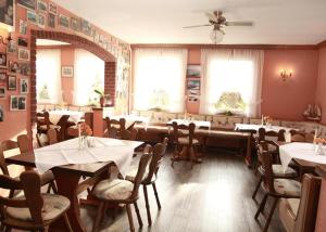 a dining room with tables and chairs and windows at Pension Bertramshof in Wismar