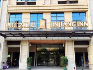 ein Gebäude mit einem Schild auf der Vorderseite in der Unterkunft Jinjiang Inn Select Suzhou Industrial Zone Jundi Manhattan Plaza in Suzhou