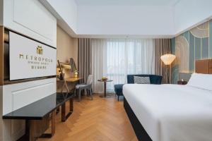 Una habitación de hotel con una cama y un escritorio y una habitación. en Jinjiang Metropolo Hotel - Ningde Wanda Plaza, en Ningde 266 fotos más