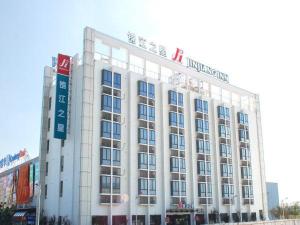 um grande edifício branco com uma placa em cima em Jinjiang Inn Shanghai Hongqiao Hinge National Exhibition Centre em Xangai