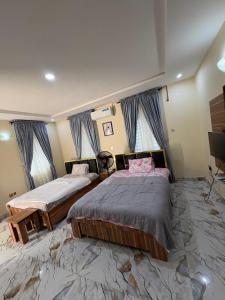 a bedroom with two beds and a flat screen tv at Bollington ADEX house 