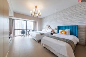 a hotel room with two beds and a window at Qingdao Tinglan Hotel Apartment (Wusi Square Mixc City Branch) in Fushansuo