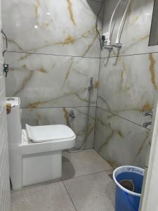 シュリーナガルにあるKoh E Noshの白いトイレと洗面台のあるバスルーム +2枚の写真