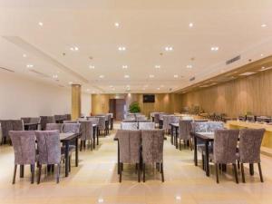 a restaurant with tables and chairs in a room at Metropolo, Taiyuan, Taiyuan Changfeng Street Subway Station in Taiyuan