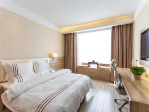 a bedroom with a large bed with a desk and a window at Metropolo, Taiyuan, Taiyuan Changfeng Street Subway Station in Taiyuan +40 photos