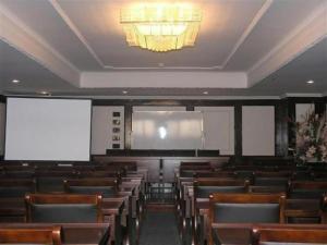 a lecture hall with wooden chairs and a chandelier at GreenTree Inn Zhangjiagang Yangshe Old Street Stadium in Zhangjiagang