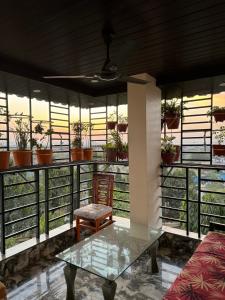 a glass table and a chair on a balcony at Vijay Cozy Corner Hostel in Navi Mumbai