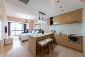 a room with a kitchen and a bedroom with a bed at Qingdao Tinglan Hotel Apartment (Wusi Square Mixc City Branch) in Fushansuo