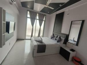 a bedroom with a bed and a large window at Hotel Majestic Royal, Akkalkot in Akalkot +41 photos