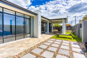 a house with glass walls and a patio at Casa Al Mare in Busselton