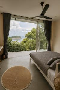 ein Schlafzimmer mit einem Bett und einem großen Fenster in der Unterkunft NEW! Sunset & Seaview 4BR 5BA Pool Villa in Ko Ma + 21 Fotos