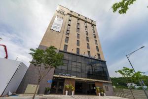 a tall building with a sign on top of it at Hotel PIED Suseong in Uksu