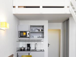 a kitchen with a sink and a microwave at Aparthotel Adagio Access La Défense - Place Charras in Courbevoie