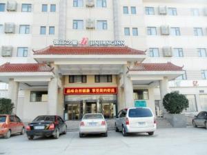 een groot gebouw met auto's geparkeerd voor het bij Jinjiang Inn Binzhou Huanghesan Road in Binzhou