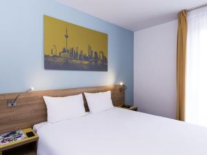 a hotel room with a bed and a painting on the wall at Aparthotel Adagio Access Paris Clamart in Clamart