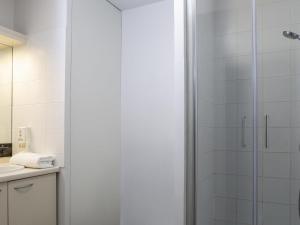 a bathroom with a shower with a glass door at Aparthotel Adagio Access Avignon in Avignon